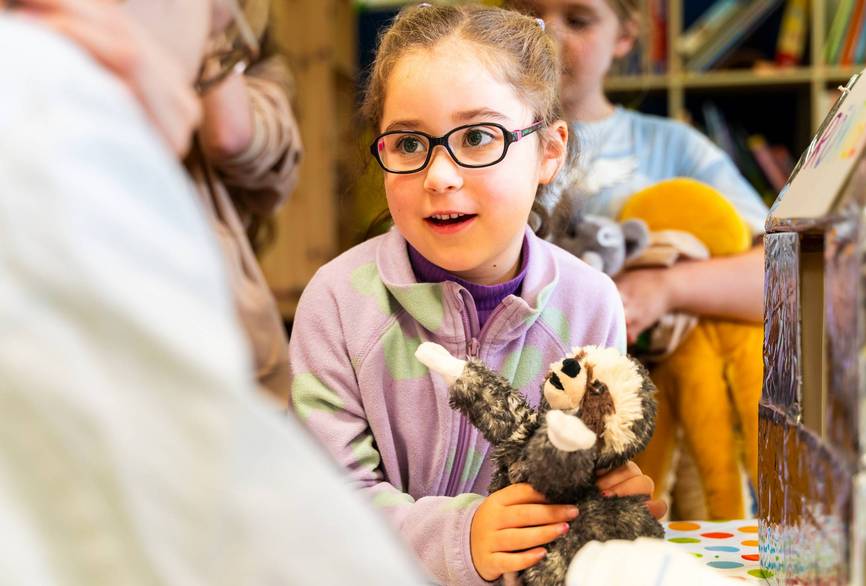 Ein Kind bringt ihr Kuscheltier in die Teddybärenklinik