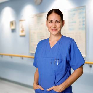 Eine Hebamme steht auf dem Flur der Geburtenstation des Charité Campus Virchow Klinikum