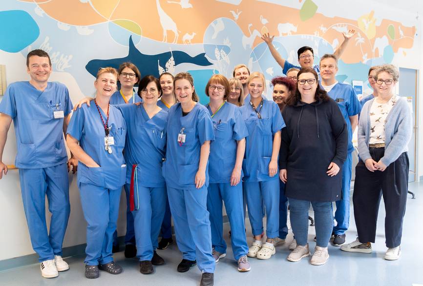 Eine Gruppe von Pflegekräften steht auf dem Flur der Kinderintensivstation.