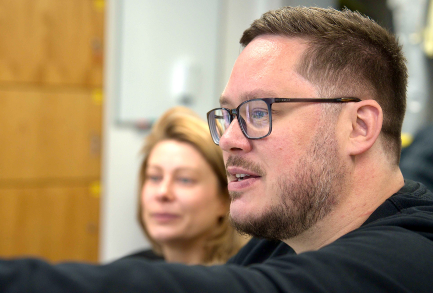 Charité Pflegekraft und Zentraler Praxisanleiter Pascal Hunger erklärt Master-Studentin Inhalte am PC