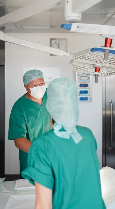 2 pflegende Mitarbeitende der Charité am OP-Tisch