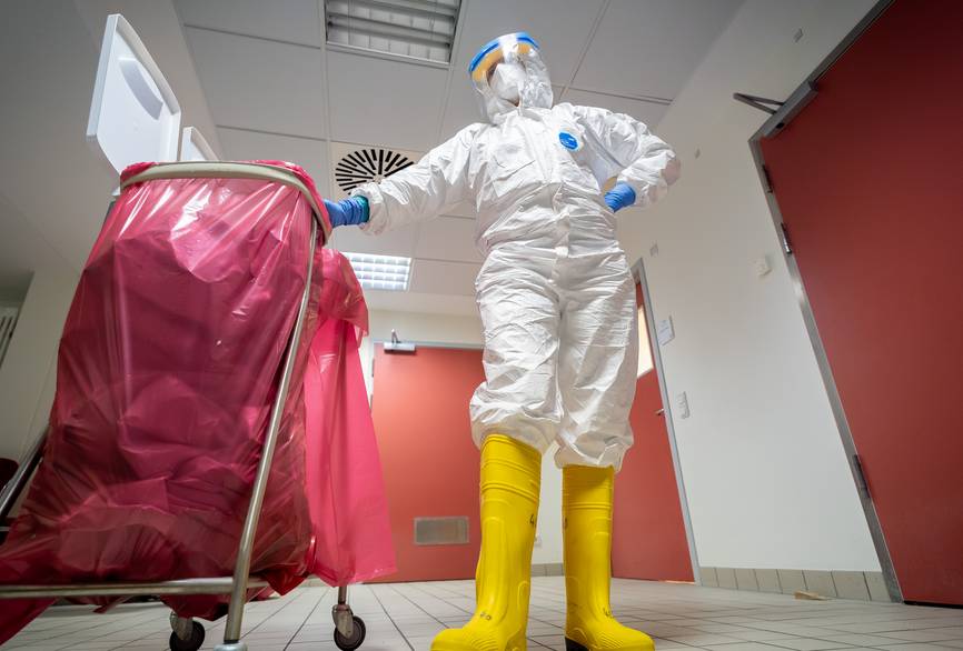 Pflegekraft auf der Sonderisolierstation hilft bei der Müllbeseitigung