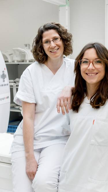 2 Mitarbeiterinnen der Radiologie stehen vor einem Kernspinntomographen