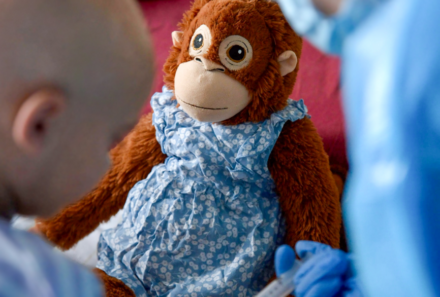 Charite Station 39i im Patientenzimmer. Pflegekraft Julia Matterei bei der Nachsorge einer jungen Patientin unter Aufsicht des Stoffäffchens Affi