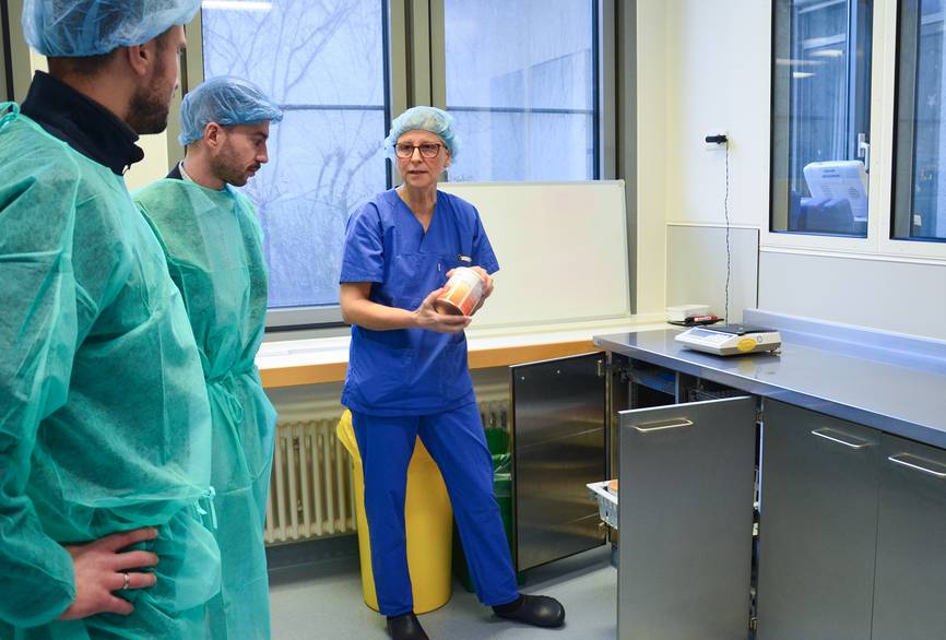 Drei Pflegekräfte bei einer Besprechung in mit Schutzkleidung und Kasacks