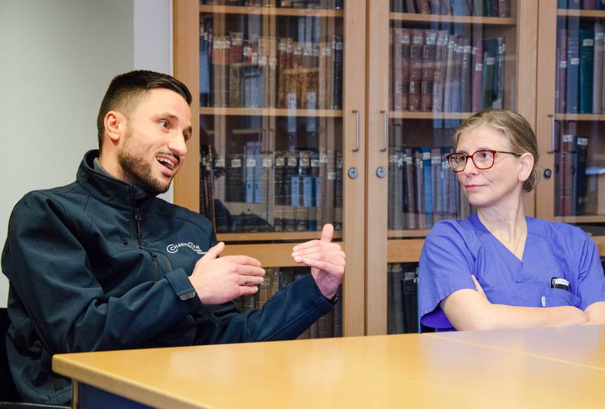 Zwei Personen sitzen an einem Tisch und besprechen sich.