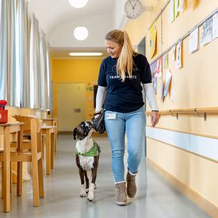 Therapiehund Rosa mit Trainerin Stephanie auf den Gängen der Kinderpsychiatrie der Charité