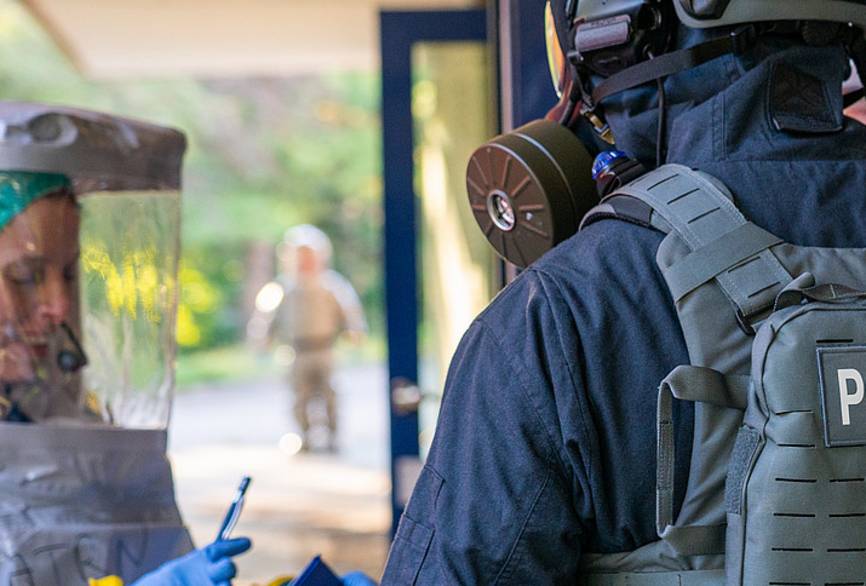 Ein Mitarbeiterin der Sonderisolierstation spricht mit einem Polizisten