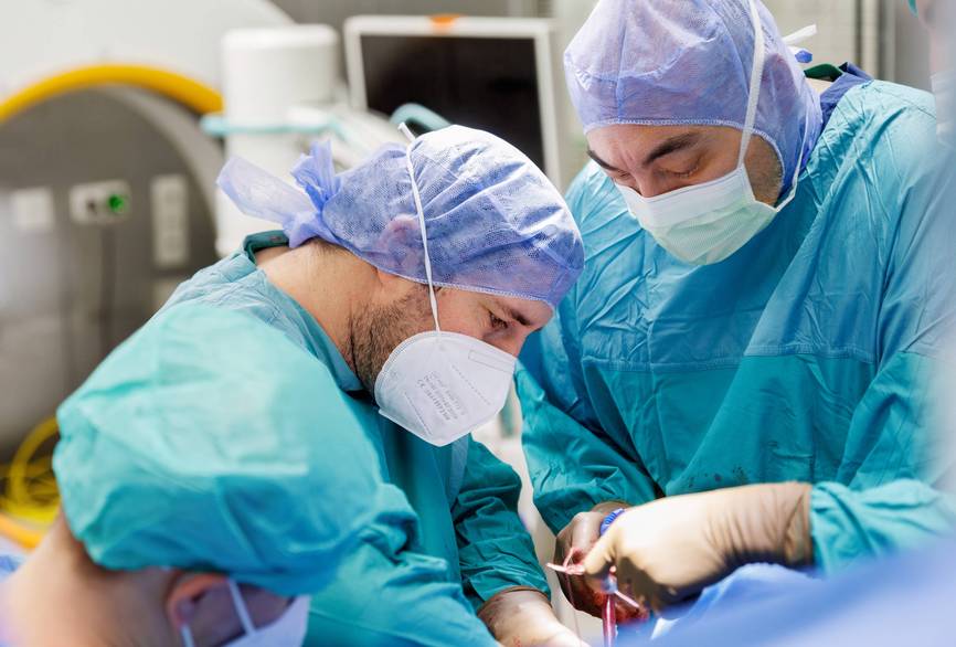 Drei Ärzte operieren konzentriert