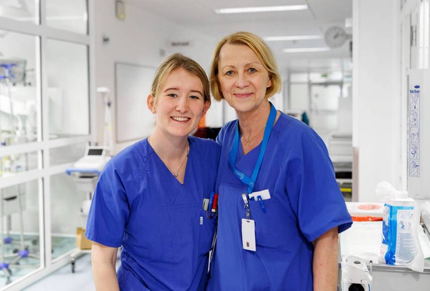 Zwei Pflegerinnen posieren vor der Kamera in der Notaufnahme