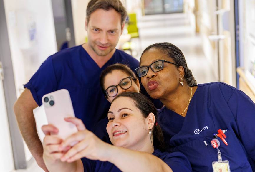 Pflegefachkräfte machen ein Selfie auf dem Stationsflur