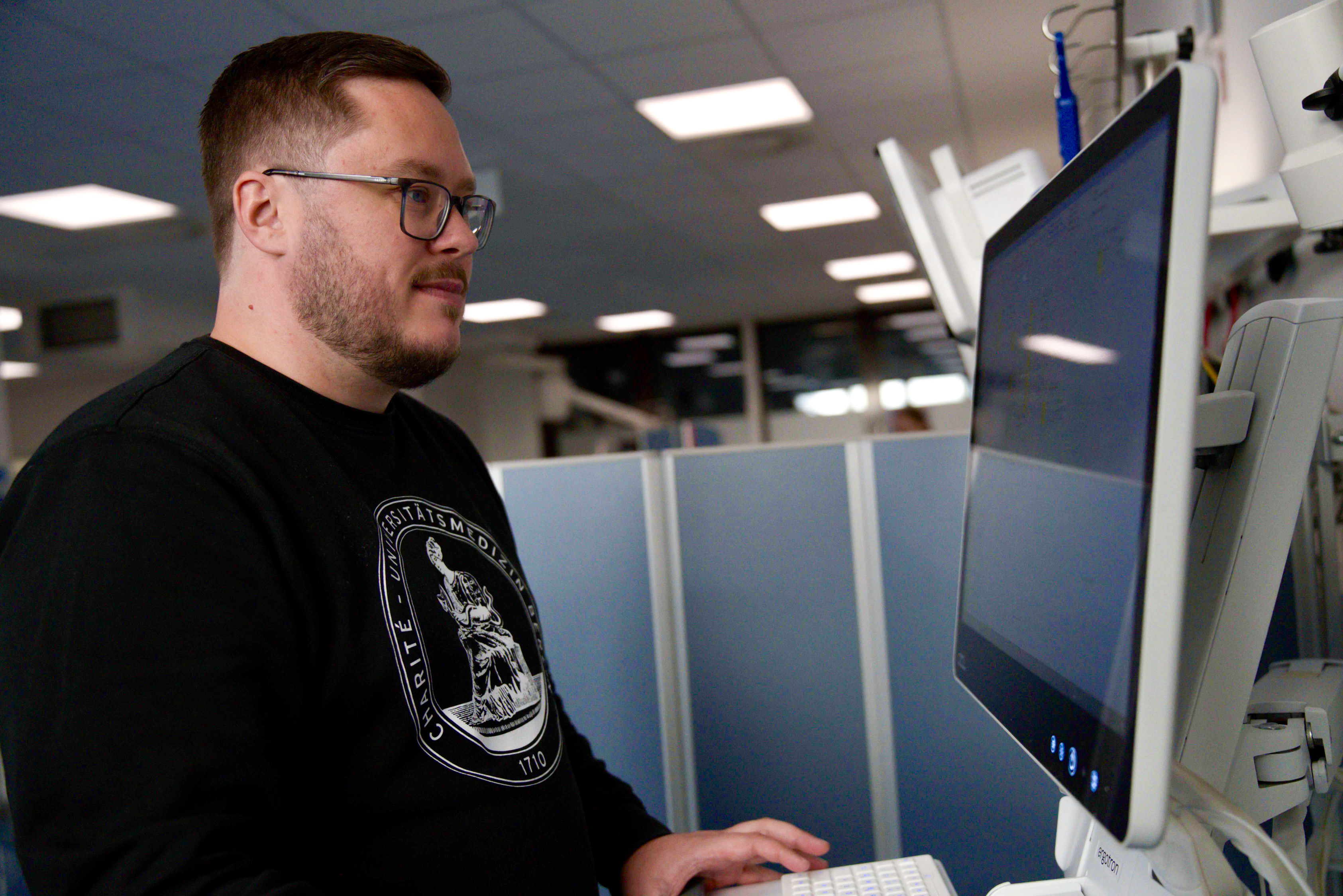 Charité Pflegefachkraft und Zentraler Praxisanleiter Pascal Hunger am Monitor eines Großraums der Zentralen Notaufnahme